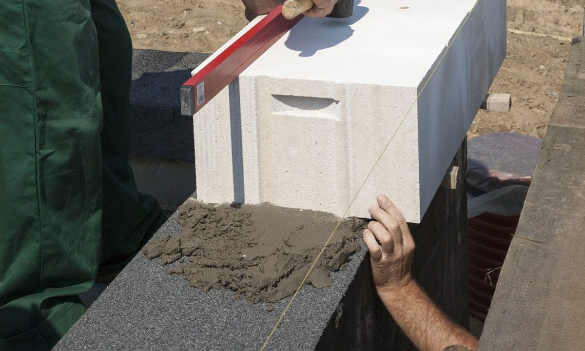Murowanie pierwszej warstwy ściany nośnej z betonu komórkowego i bloczków silikatowych. Fot. H+H