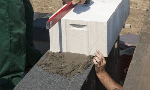 Murowanie pierwszej warstwy ściany nośnej z betonu komórkowego i bloczków silikatowych. Fot. H+H